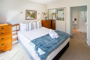 Un dormitorio con una gran cama blanca con una manta azul. en Your Home Away From Home on Barrington Street, en Christchurch