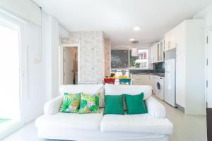 a living room with a white couch with pillows at Paraíso Frente al Mar con Piscina - By Aloha Palma in Águilas