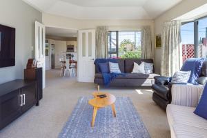 una sala de estar con un sofá y una mesa en Your Home Away From Home on Barrington Street, en Christchurch