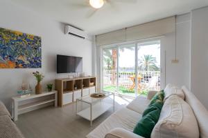 a living room with a couch and a tv at Paraíso Frente al Mar con Piscina - By Aloha Palma in Águilas