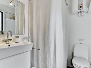 a white bathroom with a toilet and a sink at Holiday Home Judyta - 1km from the sea by Interhome in Fanø