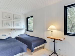 two beds in a room with a desk and a window at Holiday Home Judyta - 1km from the sea by Interhome in Fanø