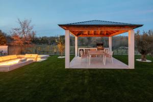 a gazebo with a table and chairs in a yard at Villa Neoma in Linardići +39 photos