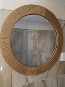 a wooden mirror on a wall in a bathroom at Modern Stand alone estate house in Mombasa