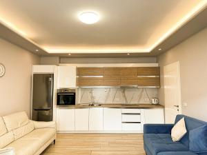 a living room with a couch and a kitchen at Luna Rooms in Golem