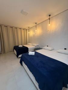 a room with two beds with blue sheets at Casa Branca Mediterrânea in Barra Grande +20 photos