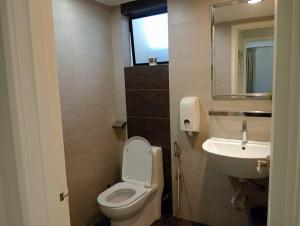 a bathroom with a white toilet and a sink at Lumut Valley in Lumut