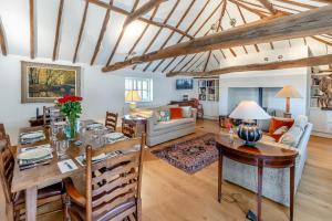 a dining room and living room with a table at Blackford Farm Cottage in Warbleton