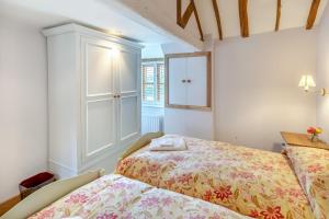 a bedroom with a bed and a cabinet and a window at Blackford Farm Cottage in Warbleton