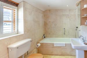 a bathroom with a bath tub and a sink at Blackford Farm Cottage in Warbleton