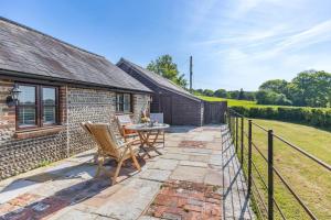 a patio with a table and chairs in front of a building at Blackford Farm Cottage in Warbleton