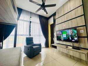 a living room with a tv and a blue chair at Group-Friendly Stay in Putrajaya & IOI City Mall in Putrajaya