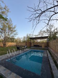 una piscina con una mesa y un cenador en Dunewood villa, en Jaipur