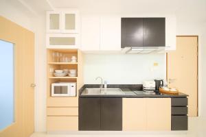 a kitchen with black and white cabinets and a sink at Kamalaya 2BR Balcony Suite at Kamala Beach in Kamala Beach +19 photos