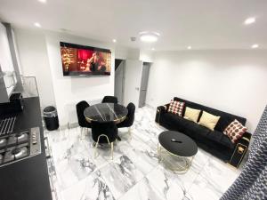 a living room with a black couch and a table at THE ROYAL BOUTIQUE MAYFAIR LODGE bY LONDON , SLEEP 8 in Hayes +15 photos