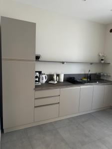 a white kitchen with white cabinets and a sink at KM30rooms in Campobasso