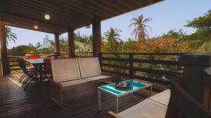 une véranda avec une table et une table dans l'établissement Appartement COCO T4 en R+1 proche du lagon, à La Saline les Bains