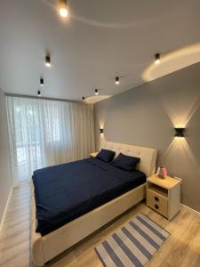 a bedroom with a large bed with a blue blanket at Buiucani Residence in Chişinău
