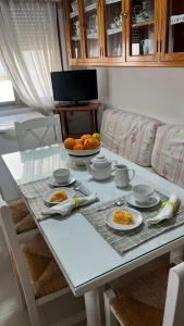 a table with plates of food and a bowl of oranges at Apartamento centrico, 5 bedrooms, 5 baños en-suite in Jerez de la Frontera +35 photos