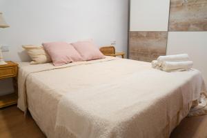 a bedroom with a large bed with pink pillows at Piso Luminoso A Metros De La Plaza De Las Flores in Murcia