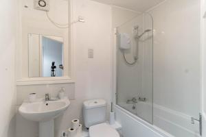 a white bathroom with a sink toilet and a shower at Lovely 1 Bed Harbour-side Apartment - Sea Views in Whitehaven