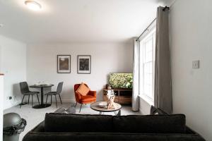 a living room with a couch and a table at Lovely 1 Bed Harbour-side Apartment - Sea Views in Whitehaven +10 photos