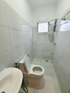 a white bathroom with a toilet and a sink at Villa Emee Nora in Panglao Island, Bohol Philippines in Libaong