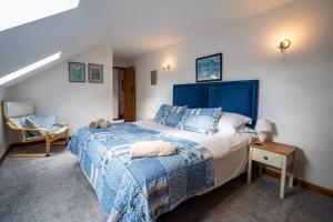 una camera con un grande letto blu e una sedia di Arthur's Cottage Visit England 4 star Cottage in Norfolk a Edingthorpe