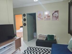 Una sala de estar con televisión y un sofá. en Ap Paulo fonteles II, en Ananindeua