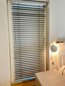 a bedroom with a large window with blinds at Bright Home in Tallinn
