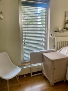 a bedroom with a bed and a chair and a window at Bright Home in Tallinn