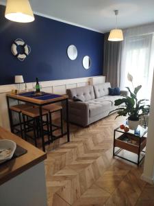 a living room with a couch and a table at Trimare Blue Apartament Sztutowo in Sztutowo