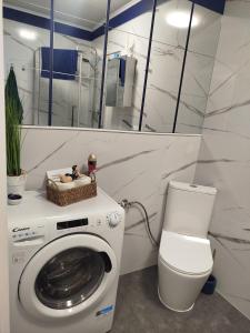 a bathroom with a washing machine and a toilet at Trimare Blue Apartament Sztutowo in Sztutowo +32 photos