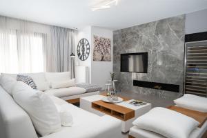 a living room with white furniture and a fireplace at Heritage Boutique Apartments in Athens