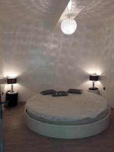 1 dormitorio blanco con 1 cama con 2 lámparas en Vue panoramique, en Agadir