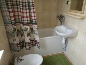 a bathroom with a sink and a tub and a toilet at Готель-хостел " Нафтуся" in Truskavets