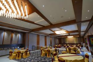 ラーイプルにあるHotel Meeravillの黄色のテーブルと椅子が並ぶ宴会場