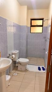 ein Badezimmer mit Toilette und Waschbecken in der Unterkunft 3rd Avenue Beach Apartments 3bedroom plus DSQ in Nyali in Mombasa