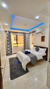 ein Schlafzimmer mit zwei Betten und einer blauen Decke in der Unterkunft 3rd Avenue Beach Apartments 3bedroom plus DSQ in Nyali in Mombasa