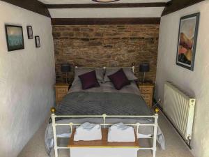 ein Schlafzimmer mit einem Bett und zwei Nachttischen in einem Zimmer in der Unterkunft Wisteria Cottage Wye Valley AONB in Llangarren