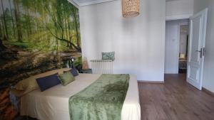 une chambre avec un lit avec un tableau sur le mur dans l'établissement Centro Ciudad Parque M & Parking Gratis, à Avilés