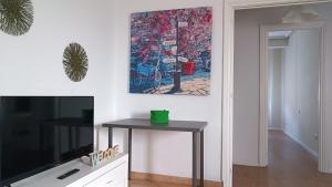 d'un salon avec une table et une peinture murale. dans l'établissement Centro Ciudad Parque M & Parking Gratis, à Avilés