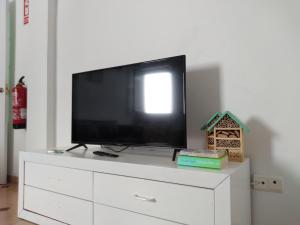 Elle comprend une télévision à écran plat installée au-dessus d'une commode blanche. dans l'établissement Centro Ciudad Parque M & Parking Gratis, à Avilés 9 autres photos