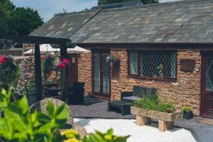 ein Steinhaus mit einer Bank davor in der Unterkunft Wisteria Cottage Wye Valley AONB in Llangarren