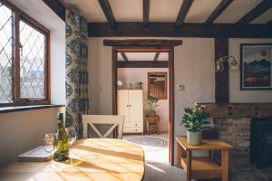 ein Wohnzimmer mit Tisch und Kamin in der Unterkunft Wisteria Cottage Wye Valley AONB in Llangarren