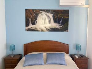 una camera da letto con un letto e un dipinto a cascata sul muro di Recanto do Açor a Vide