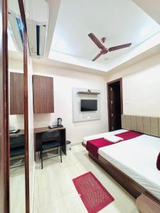 バラナシにあるHotel VIMOKSHA# RESIDENCE - Near Kashi-Vishwanath-Temple-And Ganga Ghat With-Lift-Wifi- Restaurant- Paid-Parking facilities-Newly Decorated Room- A Top Rated Premium Hotel in Varanasiのベッドと机があるホテルの部屋
