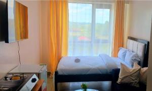 a small bedroom with a bed and a window at Bellora Urban Homes in Ongata Rongai 