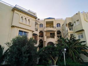 Un gran edificio con árboles delante. en Cozy apartment Chatt Meriem, en Chott Meriem