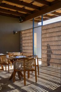 a dining room with wooden tables and chairs at Nalu Resort & SPA Adults Only Hotel in Adelianos Kampos